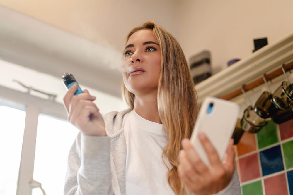 Une femme utilise une cigarette électronique pour le vapotage