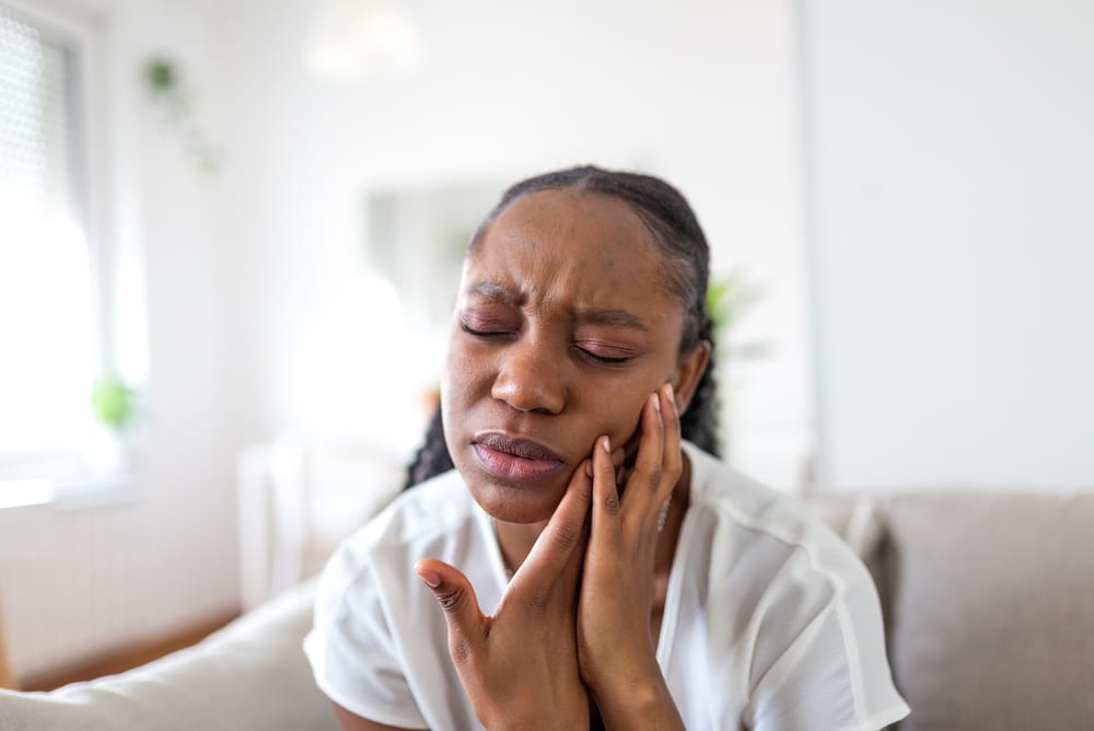 Une femme présente une rage de dents comme urgence dentaire